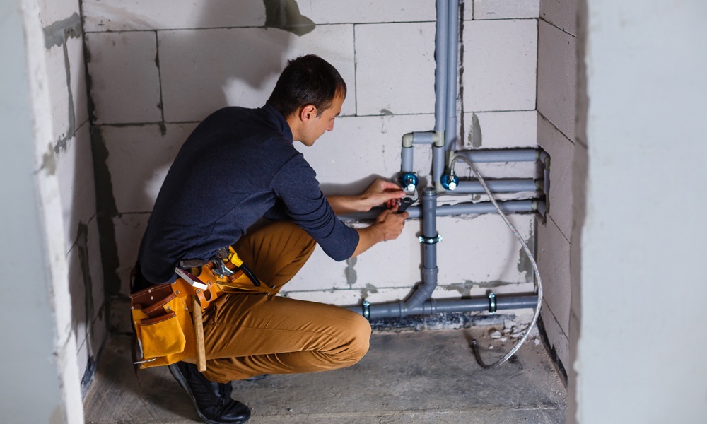 Plumber working on installed pipe